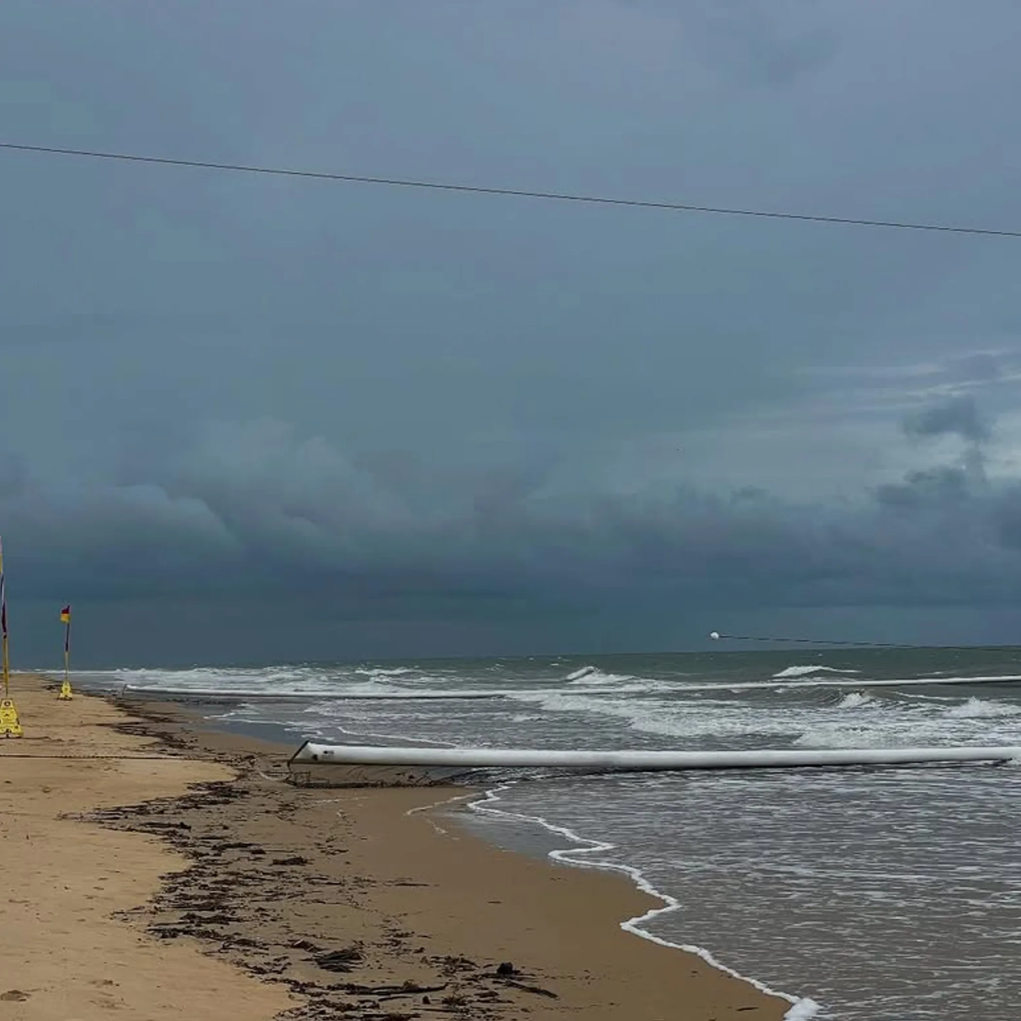 beach with safety flags and rough surf